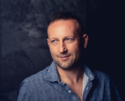 Aber sicher! Hier ist eine beschreibende Zusammenfassung, die Sie für ein Porträt oder eine Charaktervorstellung verwenden können: --- Callboy Christoph steht vor einem dunklen, strukturierten Hintergrund. Er hat kurzes braunes Haar und leichte Bartstoppeln, die seine kräftige Kieferpartie betonen. Er trägt ein blaues strukturiertes Hemd mit offenem Kragen und strahlt entspanntes Selbstbewusstsein aus. Christophs Blick ist leicht zur Seite gerichtet, und seine Lippen verziehen sich zu einem subtilen, wissenden Lächeln. --- Wenn du diese Beschreibung für kreatives Schreiben, Rollenspiele oder als Anregung für KI-Kunst anpassen oder erweitern möchtest, lass mich einfach wissen, in welche Richtung du möchtest!.