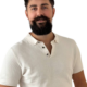 Es klingt, als würden Sie das Porträt eines Mannes namens Callboy Kaan beschreiben, der für seine dunklen Locken und seinen Vollbart bekannt ist. Er trägt ein helles, kurzärmeliges Hemd mit Kragen und lächelt sanft vor einem schlichten weißen Hintergrund. Wenn Sie eine Beschreibung zum Schreiben oder zur Erstellung eines Bildes benötigen, könnte sie etwa so aussehen: Ein Mann mit üppigen, dunklen Locken, die sein Gesicht umrahmen, trägt einen gepflegten Vollbart. Sein Gesichtsausdruck ist warm und doch sanft – ein sanftes Lächeln zeugt von Freundlichkeit und Selbstvertrauen. Er trägt ein frisches, helles, kurzärmeliges Hemd mit Kragen, das einen subtilen Kontrast zu seinem Haar und Teint bildet. Hinter ihm befindet sich ein aufgeräumter weißer Hintergrund, der die ganze Aufmerksamkeit auf seine entspannte Pose und seine zugängliche Präsenz lenkt. Lassen Sie mich wissen, wenn Sie eine andere Beschreibung oder ein anderes Format wünschen!.