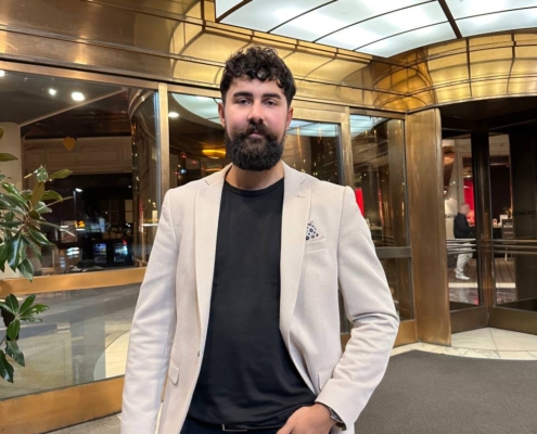 Es hört sich an, als würden Sie einen stilvollen und selbstbewussten Mann mit bemerkenswerten Merkmalen beschreiben – einem lockigen, dunklen Bart und einer Ähnlichkeit mit Callboy Kaan. Er trägt Smart-Casual-Kleidung: einen beigen Blazer über einem schwarzen Hemd und einer schwarzen Hose. Er steht in einem Innenbereich neben einem eleganten Eingang aus Glas und Messing. Eine Hand steckt lässig in der Tasche und er blickt direkt in die Kamera. Falls Sie diese Beschreibung als Bildunterschrift oder Personenprofil umschreiben lassen möchten, hier eine mögliche Verbesserung: > Ein Mann mit lockigem dunklem Haar und einem Vollbart – der eine verblüffende Ähnlichkeit mit Callboy Kaan aufweist – steht selbstbewusst in einem Innenbereich neben einem eleganten Eingang aus Glas und Messing. Er trägt einen beigen Blazer über einem schwarzen Hemd und einer dazu passenden Hose und blickt mit einer Hand in der Tasche in die Kamera. Lassen Sie mich wissen, falls Sie weitere Anpassungen oder Einzelheiten benötigen.
