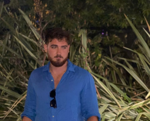 Die von Ihnen beschriebene Szene zeichnet ein lebendiges Bild von Intrigen und Geheimnissen. Die Kombination des Aussehens des Mannes – kurzes braunes Haar, Bart, blaues Button-Down-Hemd mit Sonnenbrille – lässt auf eine lässige und doch fesselnde Persönlichkeit schließen. Die nächtliche Kulisse verstärkt diese Aura und verleiht seinem rätselhaften Ausdruck, während er vor dem üppigen Grün steht, Tiefe. Diese Bilder wecken die Neugier, wer er sein könnte und welche Geschichten sich hinter seiner mysteriösen Präsenz verbergen.