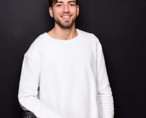 Es klingt, als würden Sie ein Bild beschreiben oder eine Beschreibung dafür anfordern, in dem Callboy Raúl zu sehen ist. Hier ist eine verfeinerte Version Ihrer Szene in einem beschreibenden, narrativen Stil: Ein junger Mann mit kurzen, lockigen braunen Haaren und einem kurz gestutzten Bart steht selbstbewusst vor einem schlichten schwarzen Hintergrund. Er ist leger gekleidet in einem weiten weißen Pullover und hellblauen Jeans, die sein entspanntes, aber stilvolles Erscheinungsbild unterstreichen. Raúl – beruflich bekannt als Callboy Raúl – lächelt herzlich in die Kamera und strahlt eine ungezwungene, selbstbewusste Aura aus. Eine Hand ruht locker auf der Rückenlehne eines eleganten schwarzen Stuhls neben ihm und vervollständigt den souveränen und zugänglichen Look. Wenn Sie diese Beschreibung an einen anderen Kontext anpassen oder weitere Details (z. B. Stimmung, Lichtdetails) hinzufügen möchten, lassen Sie es mich wissen!.