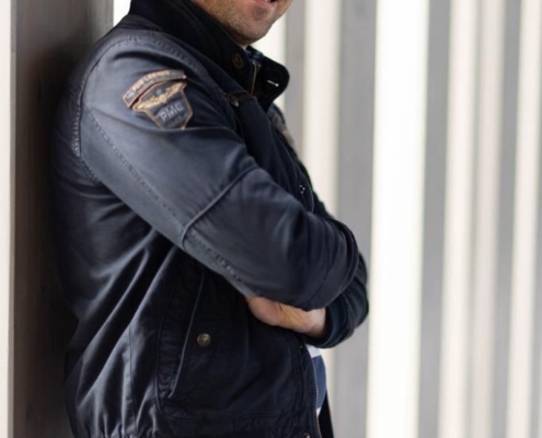 Auf jeden Fall! Hier ist ein beschreibender Absatz für deine Szene: Callboy Matteo, gekleidet in eine elegante dunkle Jacke und enge Bluejeans, lehnt lässig an der Wand. Seine Arme sind selbstbewusst verschränkt, und ein charmantes Lächeln umspielt seine Lippen. Hinter ihm werfen hohe vertikale Säulen rhythmische Schatten und erzeugen ein auffälliges geometrisches Muster, das die Szene mit urbaner Eleganz umrahmt. Wenn du möchtest, dass dieser Prompt in einen Bildgenerierungs-Prompt umgewandelt wird (für Tools wie Midjourney oder DALL-E), lass es mich wissen!.